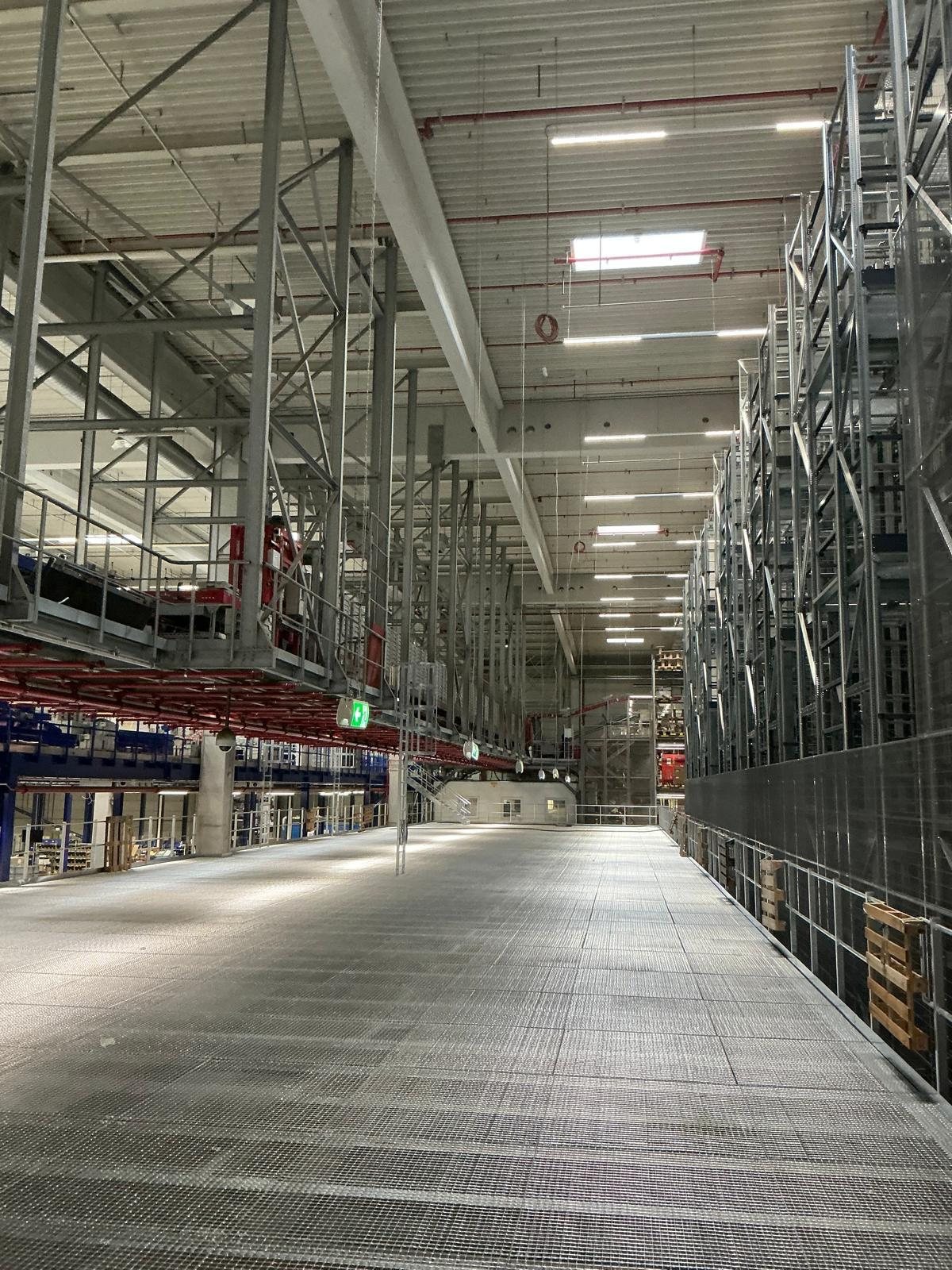 Technische Infrastruktur in einer großen Logistikhalle mit langem Mittelgang