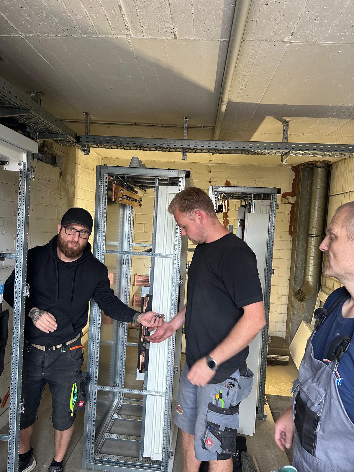 Drei Monteure von Elektro Andres beim Aufbau von Schaltschränken